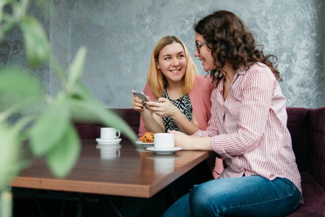 Two friends chat at a coffee shop