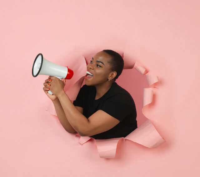 A woman uses a megaphone to let her voice be heard.