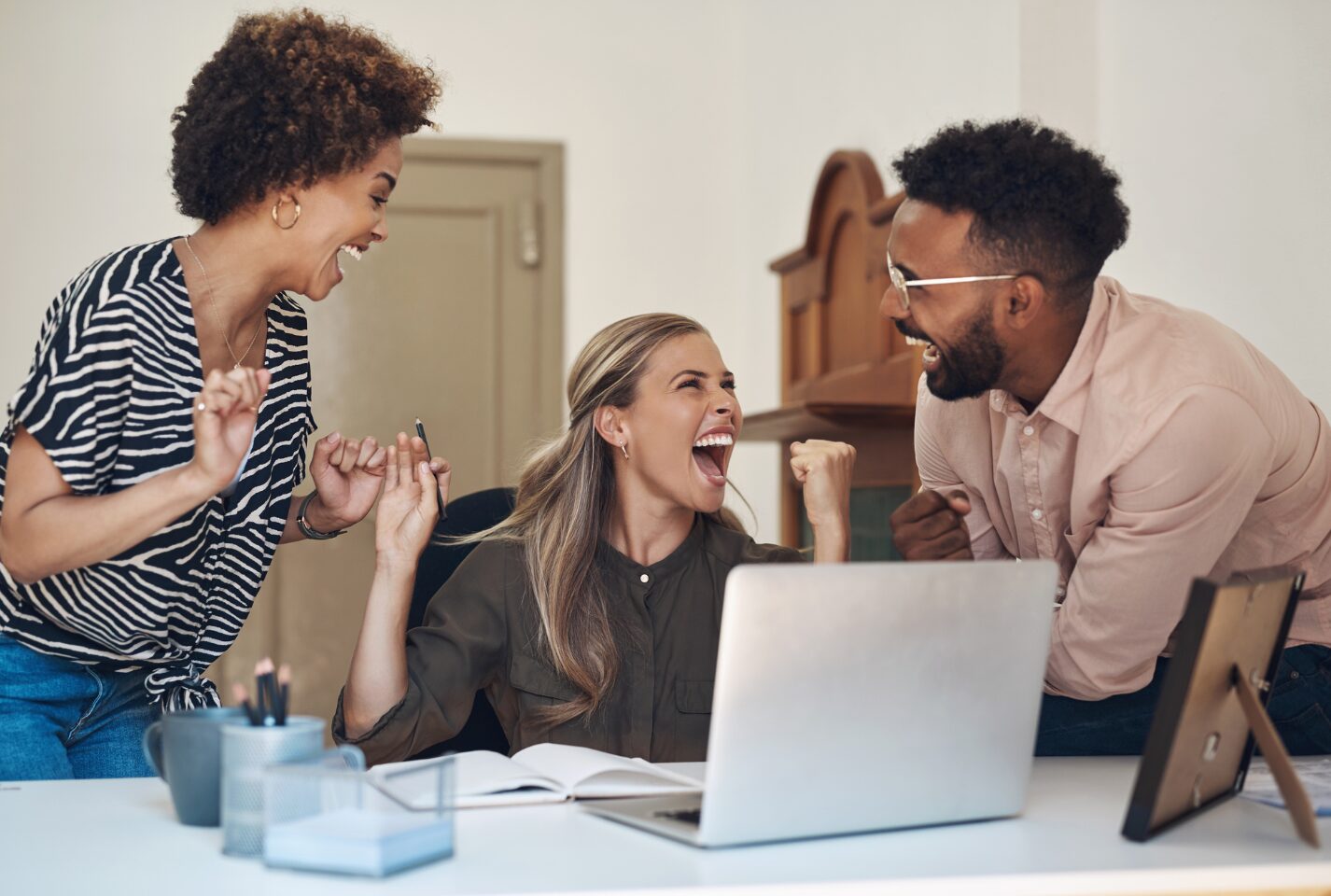 Three workmates are laughing together.