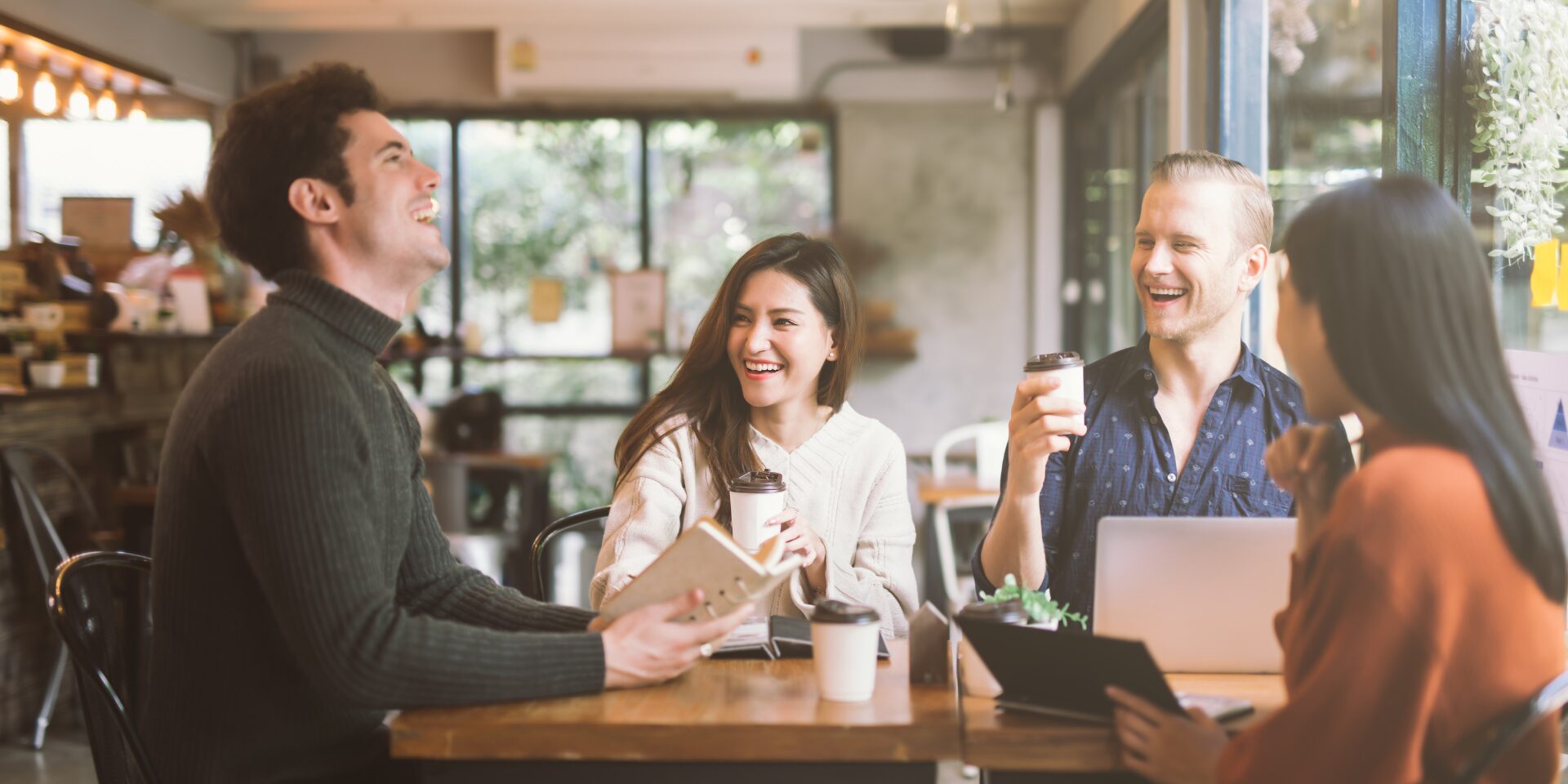 A groupd of coworkers enjoy a coffee break and chat cheerfully.