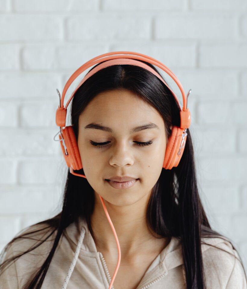 A girl listens to English audios to recognize the specific sounds.