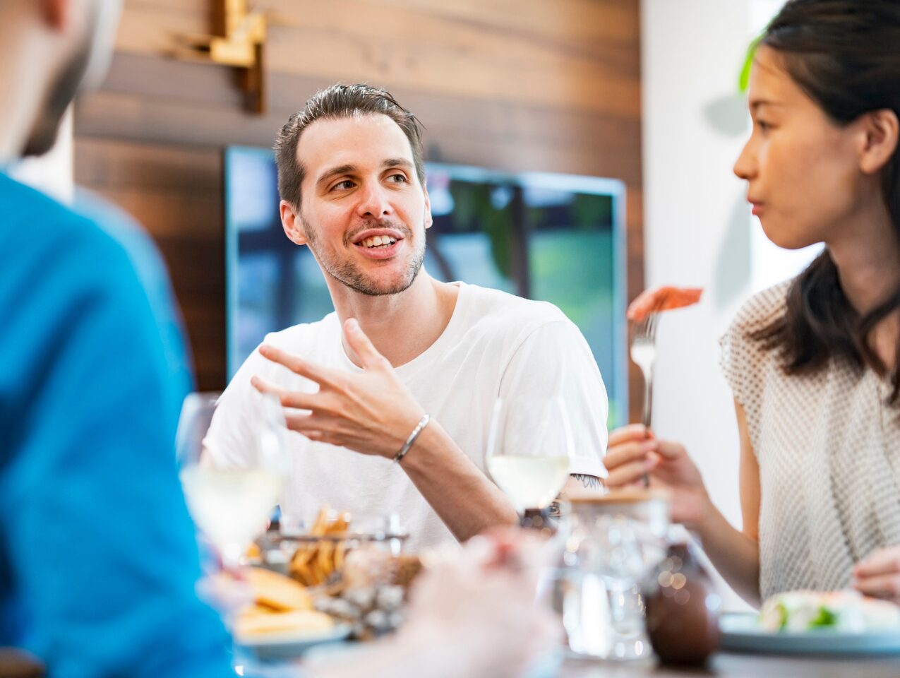 A man speaks naturally to a group of friends and colleagues.